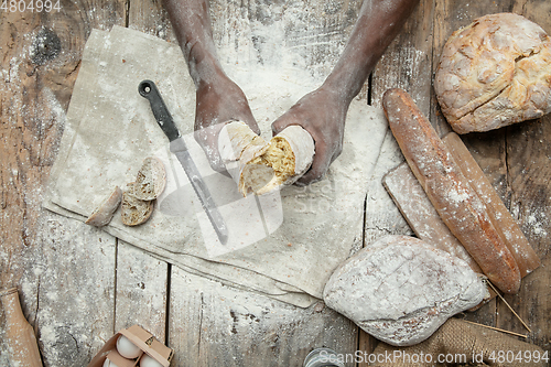 Image of Top view of african-american man cooks bread at craft kitchen