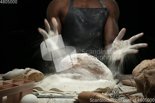 Image of Close up of african-american man cooks bread at craft kitchen