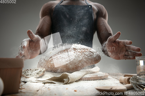 Image of Close up of african-american man cooks bread at craft kitchen