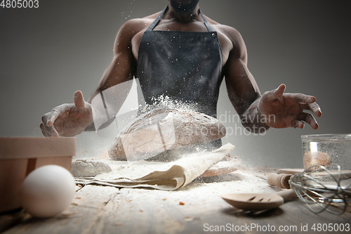 Image of Close up of african-american man cooks bread at craft kitchen