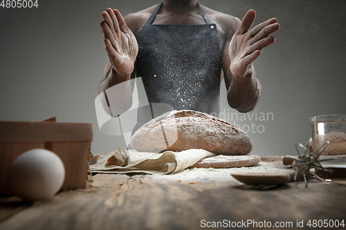 Image of Close up of african-american man cooks bread at craft kitchen