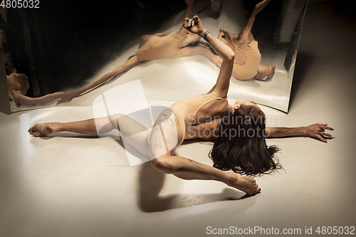 Image of Young and stylish modern ballet dancer on white background with mirrors