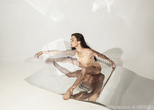 Image of Young and stylish modern ballet dancer on white background with mirrors
