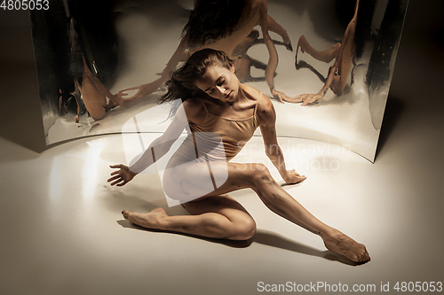 Image of Young and stylish modern ballet dancer on white background with mirrors