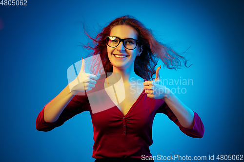 Image of Caucasian woman\'s portrait isolated on blue studio background in neon light