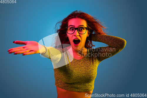 Image of Caucasian woman\'s portrait isolated on blue studio background in neon light