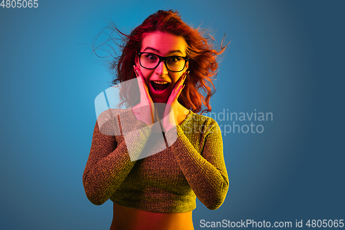 Image of Caucasian woman\'s portrait isolated on blue studio background in neon light