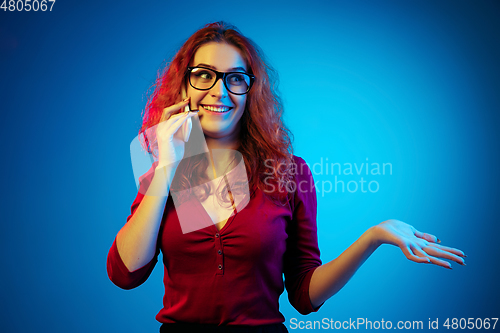 Image of Caucasian woman\'s portrait isolated on blue studio background in neon light