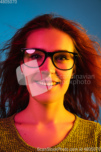 Image of Caucasian woman\'s portrait isolated on blue studio background in neon light