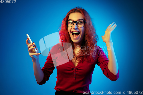 Image of Caucasian woman\'s portrait isolated on blue studio background in neon light