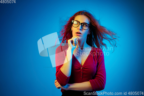 Image of Caucasian woman\'s portrait isolated on blue studio background in neon light