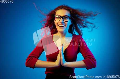 Image of Caucasian woman\'s portrait isolated on blue studio background in neon light