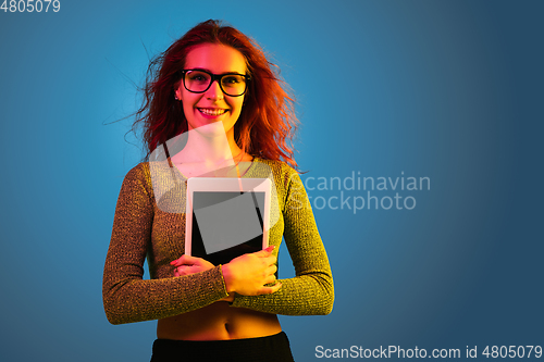 Image of Caucasian woman\'s portrait isolated on blue studio background in neon light