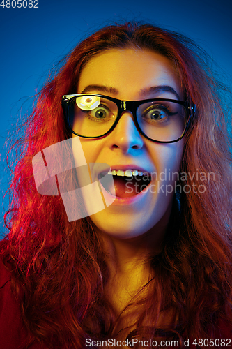 Image of Caucasian woman\'s portrait isolated on blue studio background in neon light