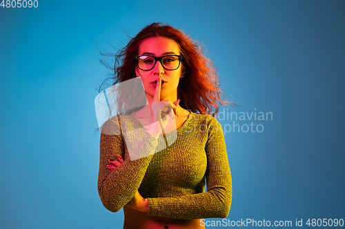 Image of Caucasian woman\'s portrait isolated on blue studio background in neon light