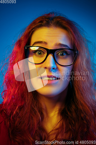 Image of Caucasian woman\'s portrait isolated on blue studio background in neon light
