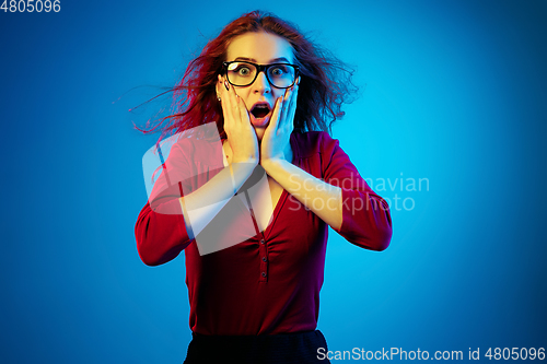 Image of Caucasian woman\'s portrait isolated on blue studio background in neon light