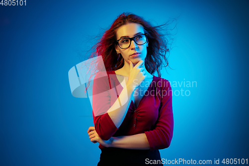 Image of Caucasian woman\'s portrait isolated on blue studio background in neon light