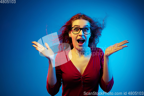 Image of Caucasian woman\'s portrait isolated on blue studio background in neon light