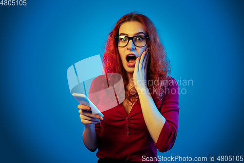 Image of Caucasian woman\'s portrait isolated on blue studio background in neon light
