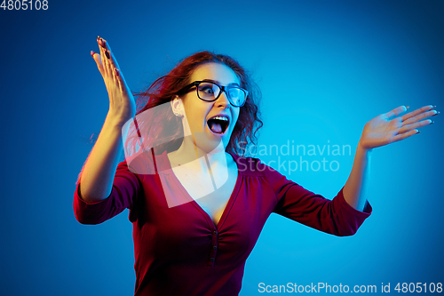 Image of Caucasian woman\'s portrait isolated on blue studio background in neon light