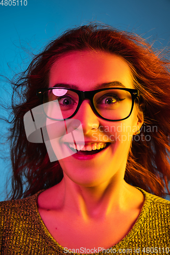 Image of Caucasian woman\'s portrait isolated on blue studio background in neon light