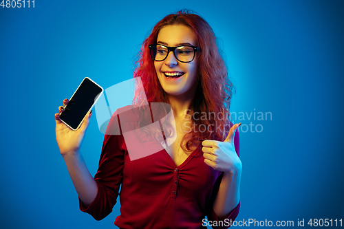 Image of Caucasian woman\'s portrait isolated on blue studio background in neon light