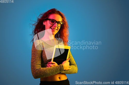Image of Caucasian woman\'s portrait isolated on blue studio background in neon light