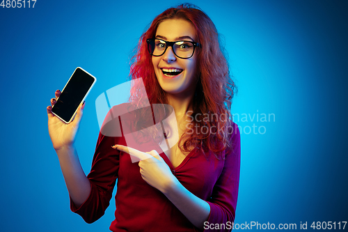 Image of Caucasian woman\'s portrait isolated on blue studio background in neon light