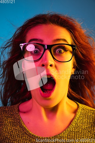Image of Caucasian woman\'s portrait isolated on blue studio background in neon light