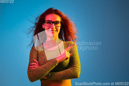 Image of Caucasian woman\'s portrait isolated on blue studio background in neon light