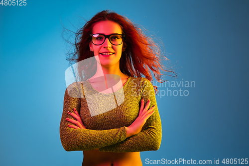 Image of Caucasian woman\'s portrait isolated on blue studio background in neon light