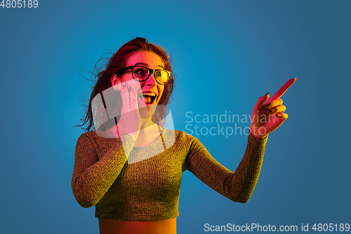 Image of Caucasian woman\'s portrait isolated on blue studio background in neon light