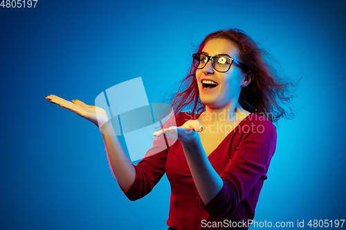 Image of Caucasian woman\'s portrait isolated on blue studio background in neon light