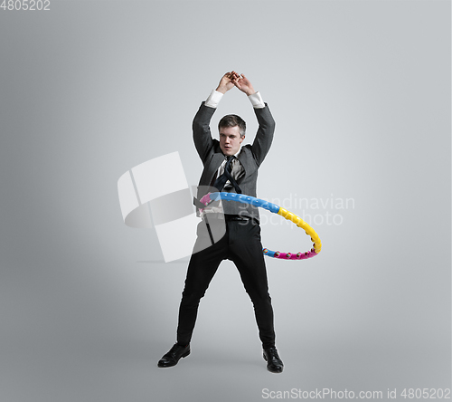 Image of Caucasian man in office clothes training isolated on grey studio background