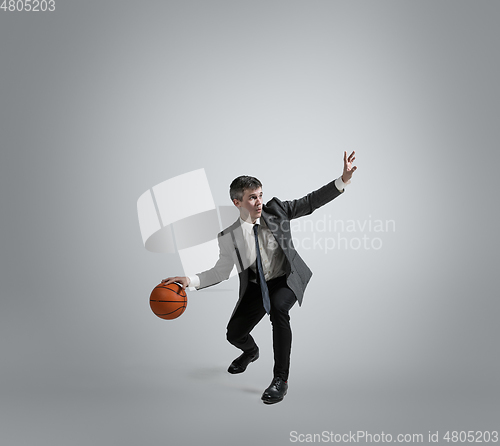 Image of Caucasian man in office clothes training isolated on grey studio background