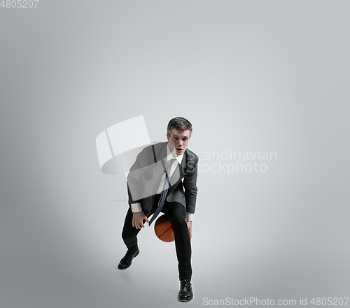 Image of Caucasian man in office clothes training isolated on grey studio background