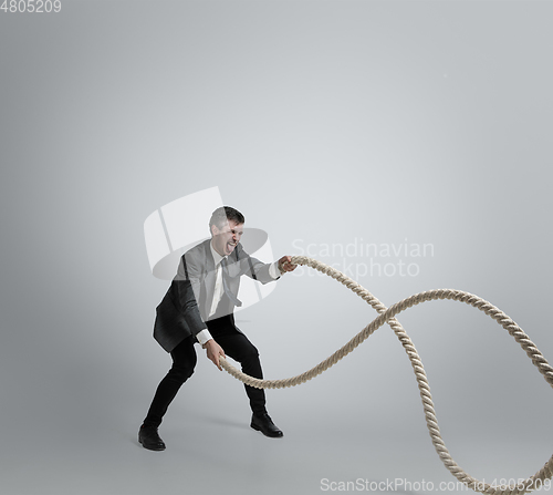 Image of Caucasian man in office clothes training isolated on grey studio background