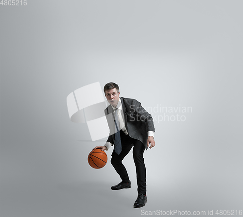 Image of Caucasian man in office clothes training isolated on grey studio background