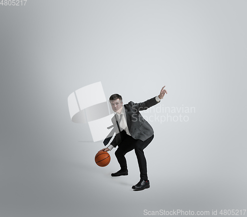 Image of Caucasian man in office clothes training isolated on grey studio background