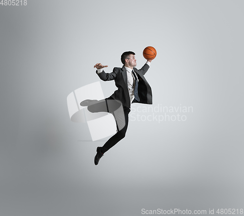 Image of Caucasian man in office clothes training isolated on grey studio background