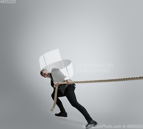 Image of Caucasian man in office clothes training isolated on grey studio background