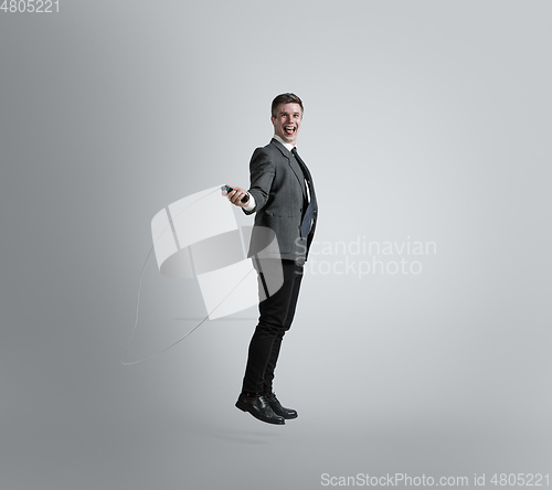 Image of Caucasian man in office clothes training isolated on grey studio background