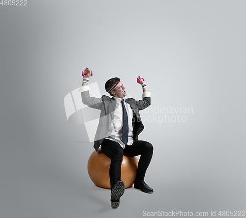 Image of Caucasian man in office clothes training isolated on grey studio background