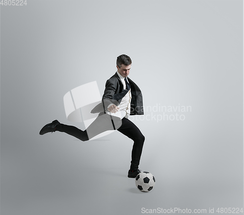 Image of Caucasian man in office clothes training isolated on grey studio background