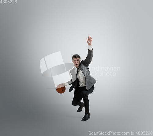 Image of Caucasian man in office clothes training isolated on grey studio background