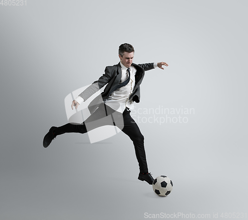 Image of Caucasian man in office clothes training isolated on grey studio background