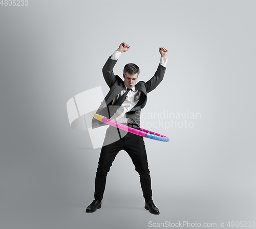 Image of Caucasian man in office clothes training isolated on grey studio background