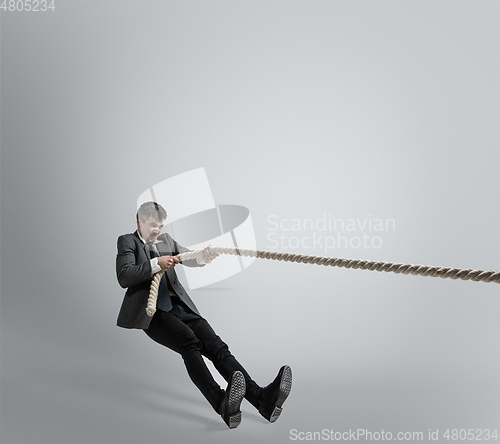 Image of Caucasian man in office clothes training isolated on grey studio background