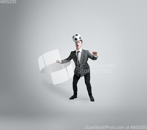 Image of Caucasian man in office clothes training isolated on grey studio background